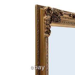 Grand miroir en bois sculpté doré, orné et fixé au mur, de taille réelle 173 x 87 cm de longueur.